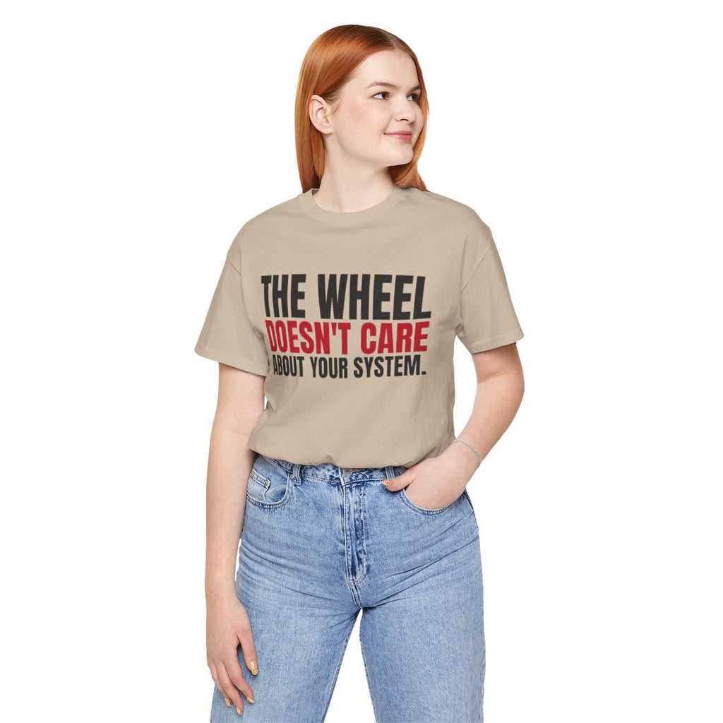 The Wheel Doesn't Care About Your System. — Roulette Tee (Tan, worn, front)
